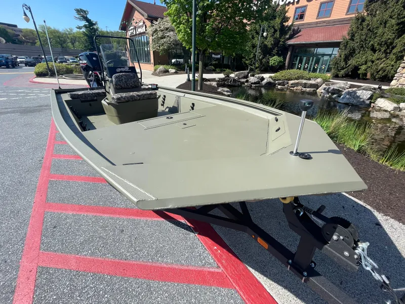 Slide: The Image of 2025 Tracker Grizzly 1860 CC boat on trailer outside a store. - 2