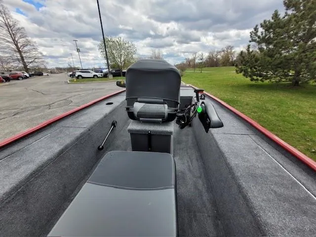 Slide: The Image of 2025 Tracker Panfish 17 boat interior with seating and steering, parked outdoors. - 4