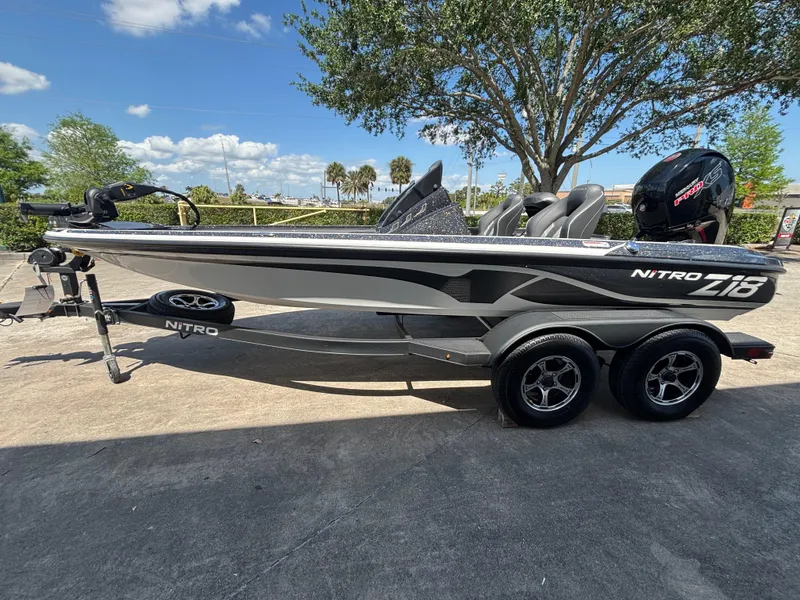 Slide: The Image of 2024 Nitro Z18 boat on trailer, parked outdoors under a clear blue sky. - 0
