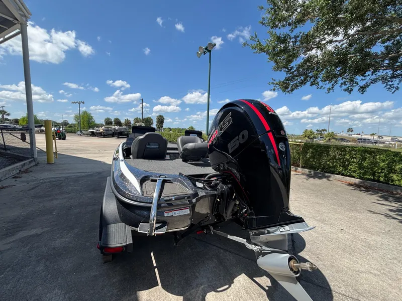 Slide: The Image of 2024 Nitro Z18 boat with powerful outboard motor, parked outdoors under a clear blue sky. - 2