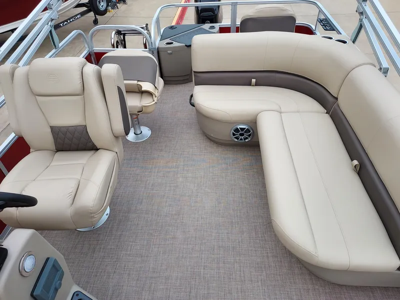 Slide: The Image of 2025 Sun Tracker Party Barge 18 DLX interior with beige seating and spacious layout. - 2