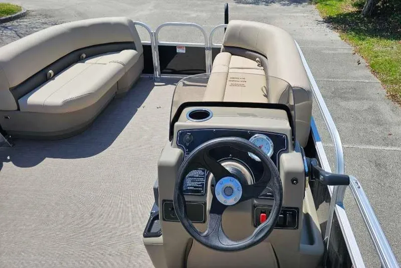 Slide: The Image of 2025 Sun Tracker Party Barge 16 DLX interior with steering wheel and seating. - 4