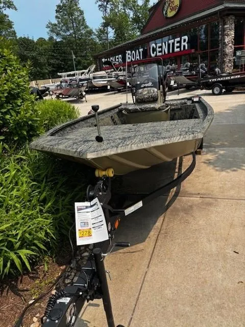 Slide: The Image of 2025 Tracker Grizzly 1860 CC boat displayed at a boat center. - 2