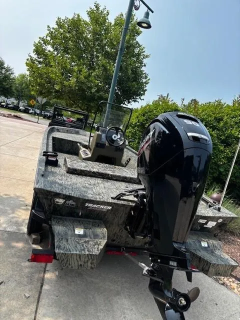 Slide: The Image of 2025 Tracker Grizzly 1860 CC boat with powerful outboard motor, parked outdoors. - 3