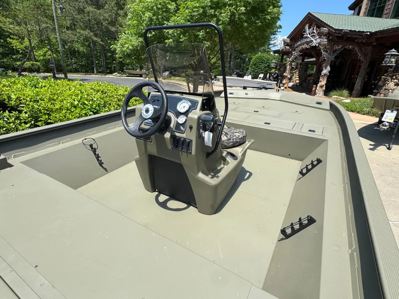 Slide: The Image of 2025 Tracker Grizzly 2072 CC boat with central console, outdoors in a sunny setting. - 2