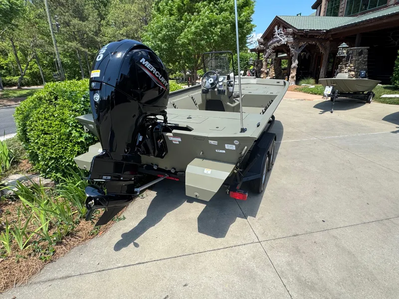 Slide: The Image of 2025 Tracker Grizzly 2072 CC boat with Mercury engine, parked outdoors on a sunny day. - 3
