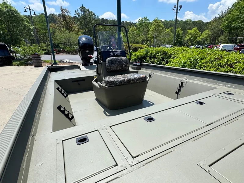 Slide: The Image of 2025 Tracker Grizzly 2072 CC boat with center console, parked outdoors on a sunny day. - 4