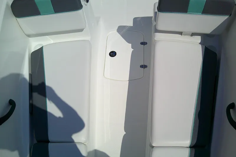 Slide: The Image of 2025 Tahoe T16 boat interior with white and teal seating, storage compartment, and shadow. - 11