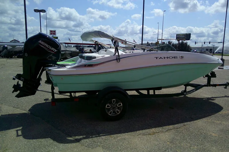 Slide: The Image of 2025 Tahoe T16 boat with Mercury engine on trailer, parked outdoors. - 3