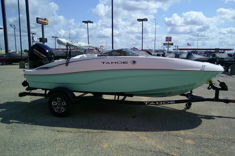 Slide: The Image of 2025 Tahoe T16 boat on trailer in parking lot under cloudy sky. - 5