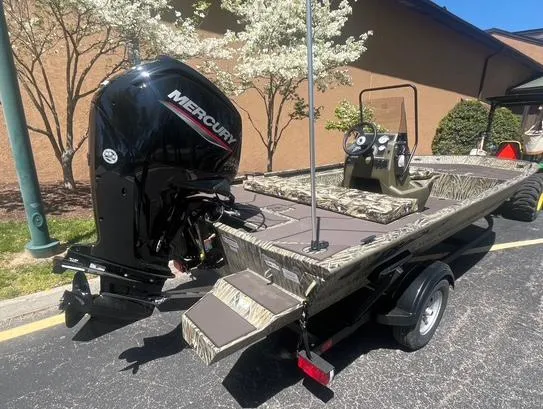 Slide: The Image of 2025 Tracker Grizzly 1860 CC boat with Mercury engine, parked outdoors. - 3