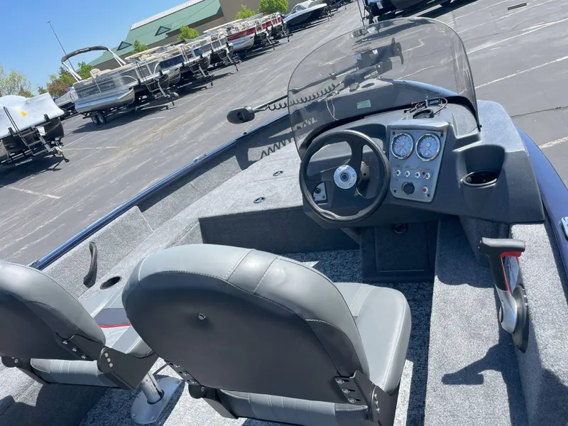 Slide: The Image of 2025 Tracker Pro Guide V-16 SC boat interior with steering console and seating. - 3