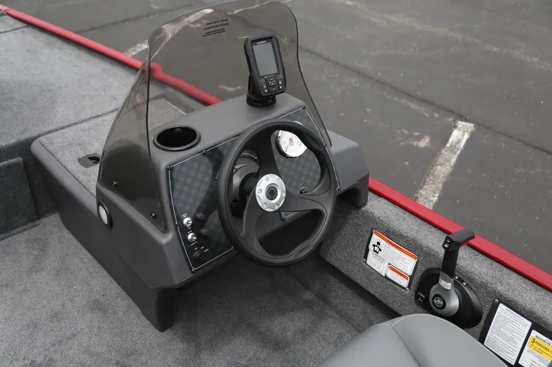 Slide: The Image of 2025 Tracker Bass Tracker Classic XL boat dashboard with steering wheel and control panel. - 2