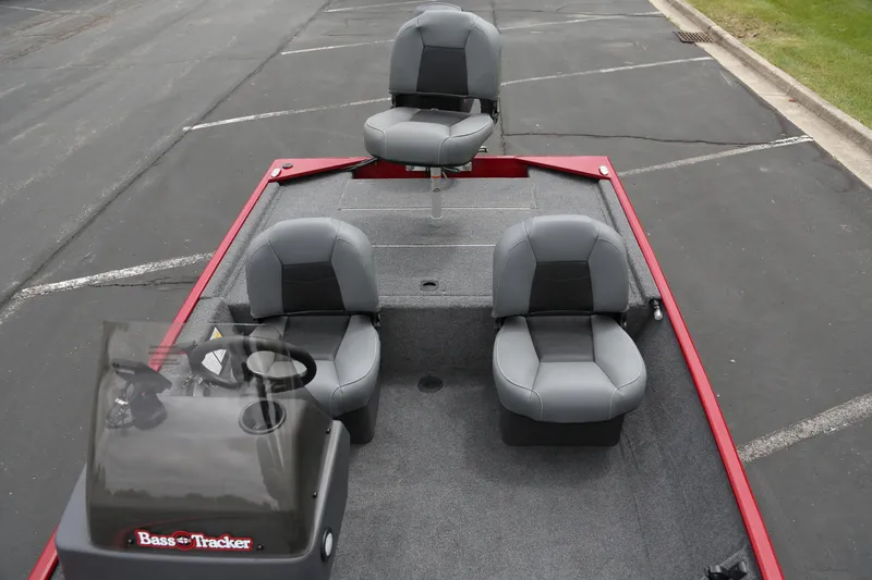 Slide: The Image of 2025 Tracker Bass Tracker Classic XL boat with gray seating and red trim in a parking lot. - 5