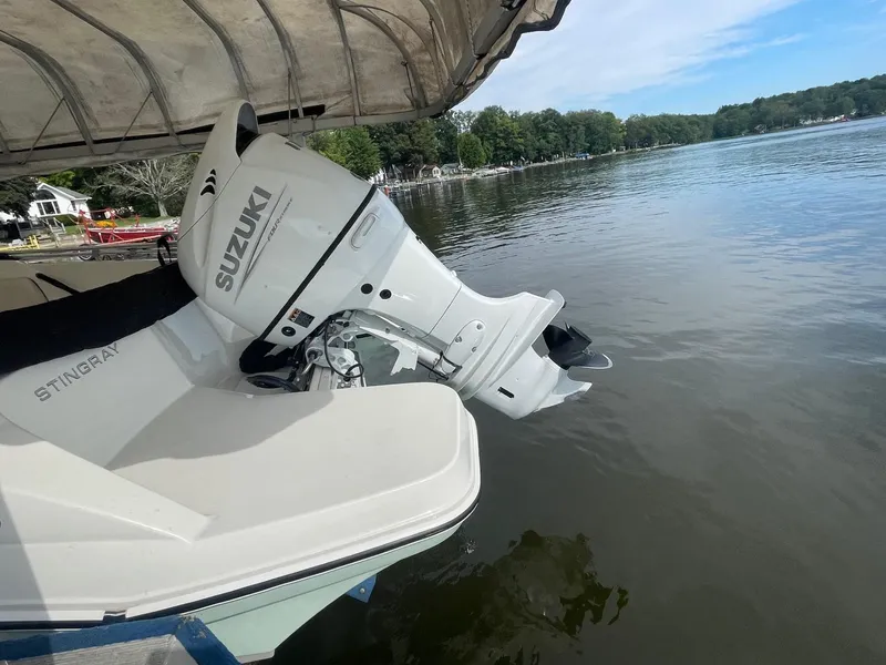 Slide: The Image of 2022 Stingray 191 DC boat with Suzuki outboard motor on a calm lake. - 4