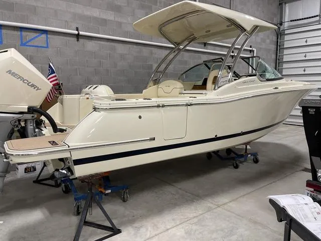 Slide: The Image of 2023 Chris-Craft Calypso 24 boat in a garage, featuring a Mercury outboard motor. - 25