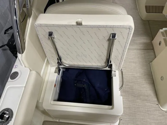Slide: The Image of 2023 Chris-Craft Calypso 24 boat seat storage compartment with open lid, revealing interior. - 28