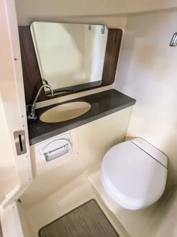 Slide: The Image of 2023 Chris-Craft Calypso 24 boat bathroom with sink, mirror, and toilet. - 37