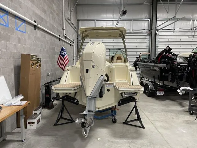 Slide: The Image of 2023 Chris-Craft Calypso 24 boat in a garage, American flag displayed. - 41