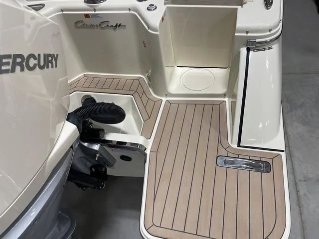 Slide: The Image of 2023 Chris-Craft Calypso 24 boat deck with Mercury engine, featuring teak-style flooring. - 44