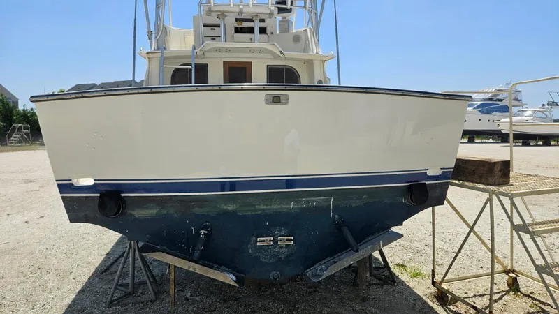 Slide: The Image of 1985 Blackfin 32 Flybridge boat on dry dock, rear view, sunny day. - 14