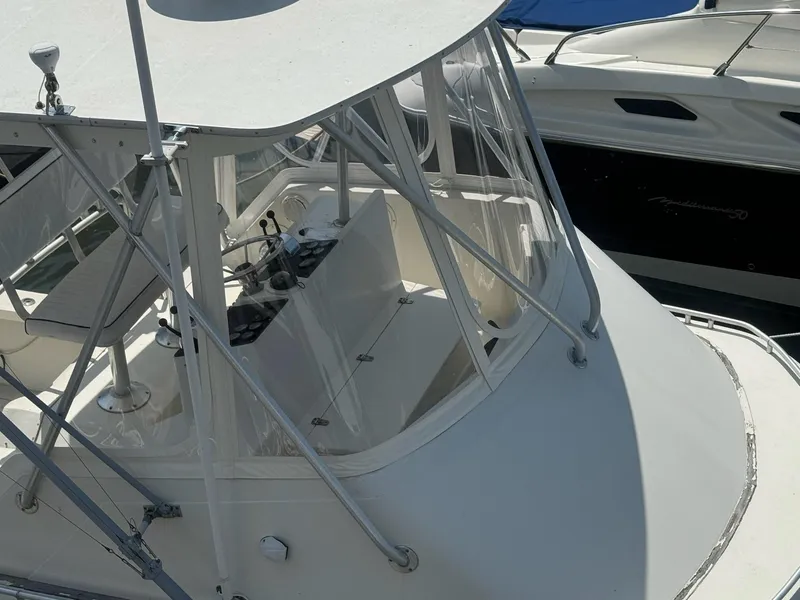Slide: The Image of 1985 Blackfin 32 Flybridge boat with enclosed helm, docked alongside another vessel. - 4