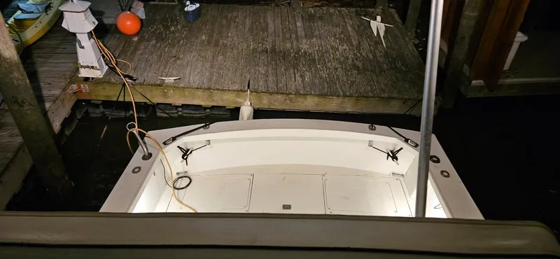 Slide: The Image of 1985 Blackfin 32 Flybridge boat docked at night, illuminated deck, wooden pier in background. - 9