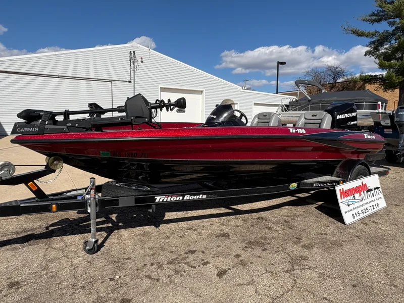 Slide: The Image of 2007 Triton Tr-186 SC bass boat on trailer, red and black, parked outdoors. - 1