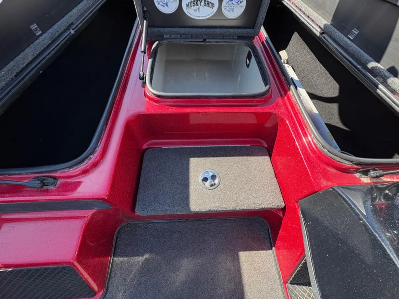 Slide: The Image of 2007 Triton Tr-186 SC boat interior with open storage compartment, red and black design. - 12