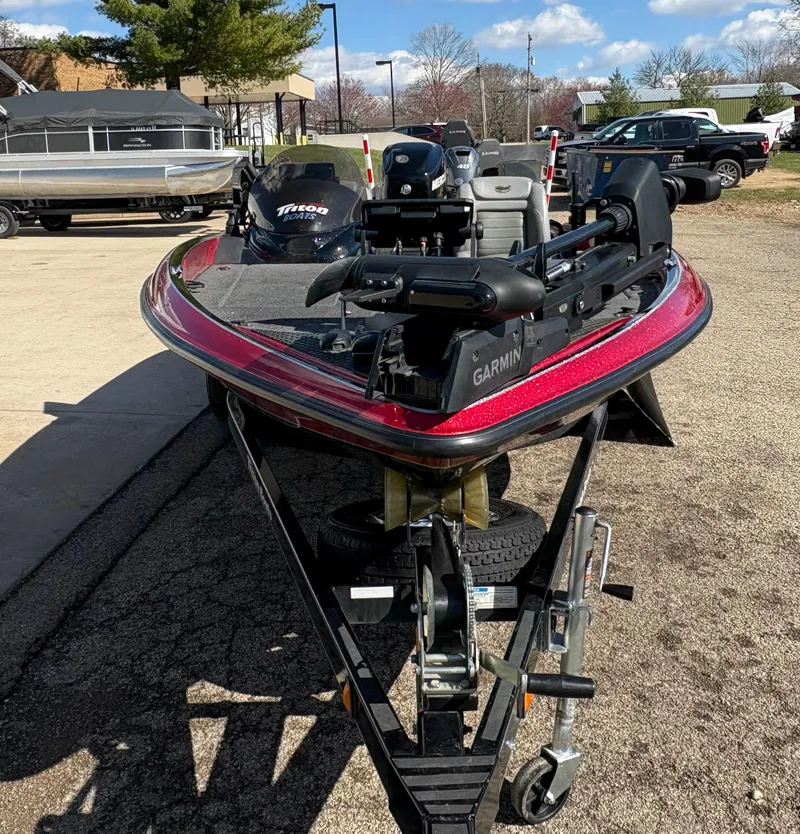 Slide: The Image of 2007 Triton Tr-186 SC boat on trailer, featuring Garmin equipment, parked outdoors. - 2