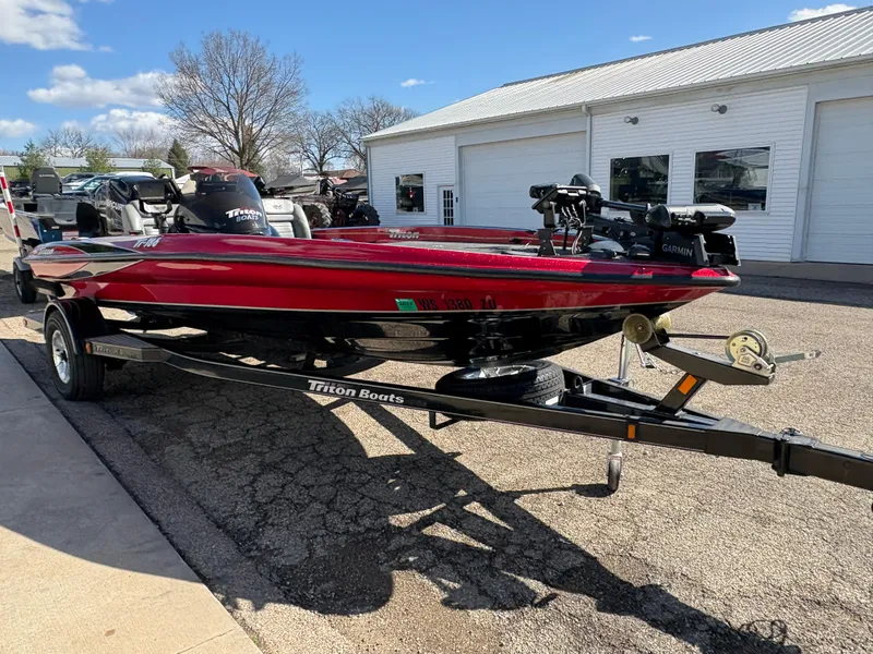 Slide: The Image of 2007 Triton Tr-186 SC red boat on trailer, parked outside a garage under a clear sky. - 3