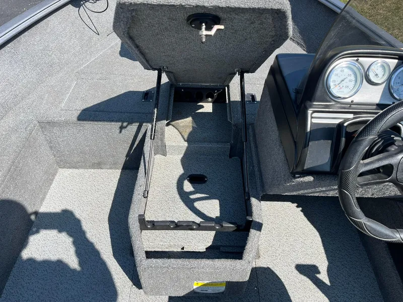 Slide: The Image of 2017 Lund 1750 Rebel XS SS boat interior with open storage compartment and dashboard. - 15