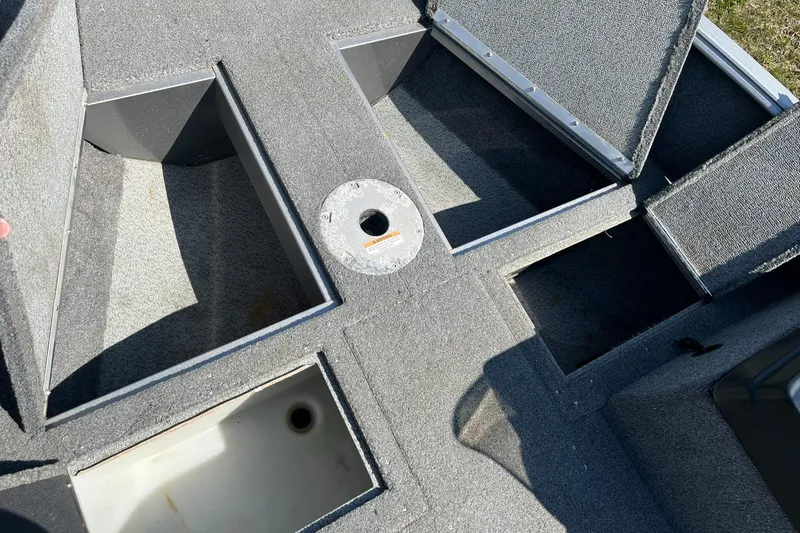 Slide: The Image of 2017 Lund 1750 Rebel XS SS boat storage compartments, open and empty, showing interior layout. - 21