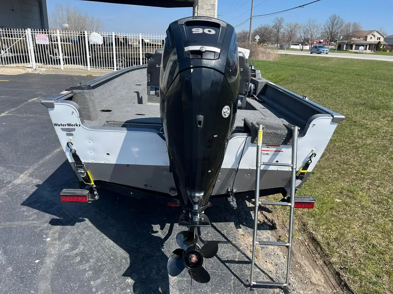 Slide: The Image of 2017 Lund 1750 Rebel XS SS boat with outboard motor and ladder, parked on pavement. - 3