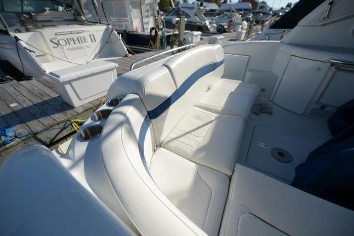 Slide: The Image of 2007 Formula 34 PC boat interior with white seating and cup holders at a marina. - 17