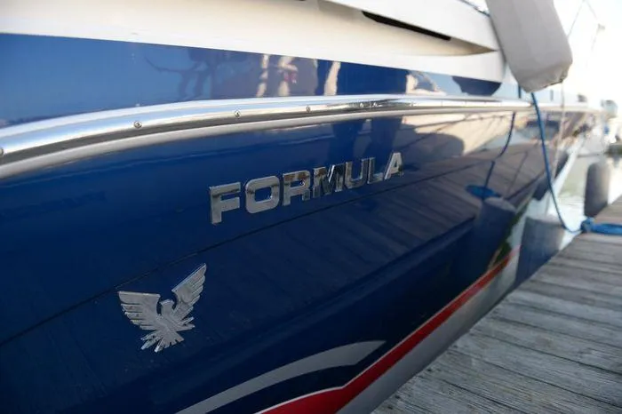 Slide: The Image of 2007 Formula 34 PC boat docked, featuring sleek blue hull and emblem. - 5