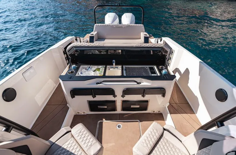 Slide: The Image of 2025 Navan S30 boat interior with outdoor kitchen and seating, on clear blue water. - 8