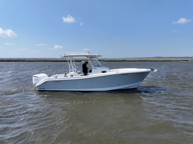 Slide: The Image of 2022 Edgewater 280CC boat cruising on open water under a clear blue sky. - 1