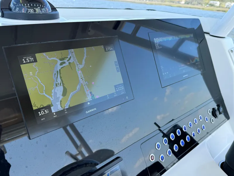 Slide: The Image of Edgewater 280CC 2022 boat dashboard with navigation screens and controls. - 11