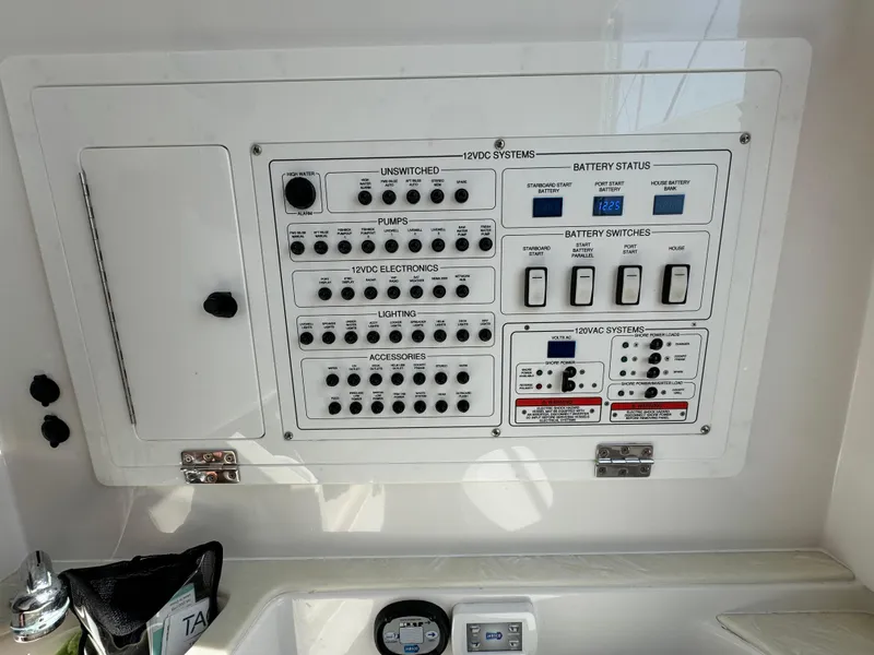 Slide: The Image of Control panel of a 2022 Edgewater 280CC boat, featuring switches and battery status indicators. - 23