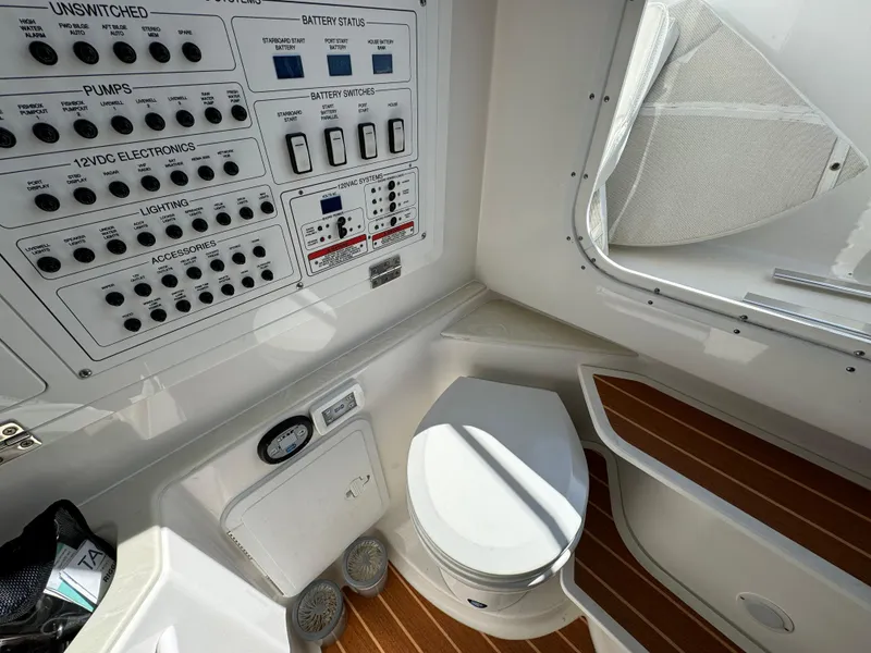 Slide: The Image of 2022 Edgewater 280CC boat interior with control panel and marine toilet. - 24