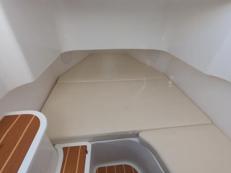 Slide: The Image of 2022 Edgewater 280CC cabin interior with cushioned seating and wooden steps. - 26