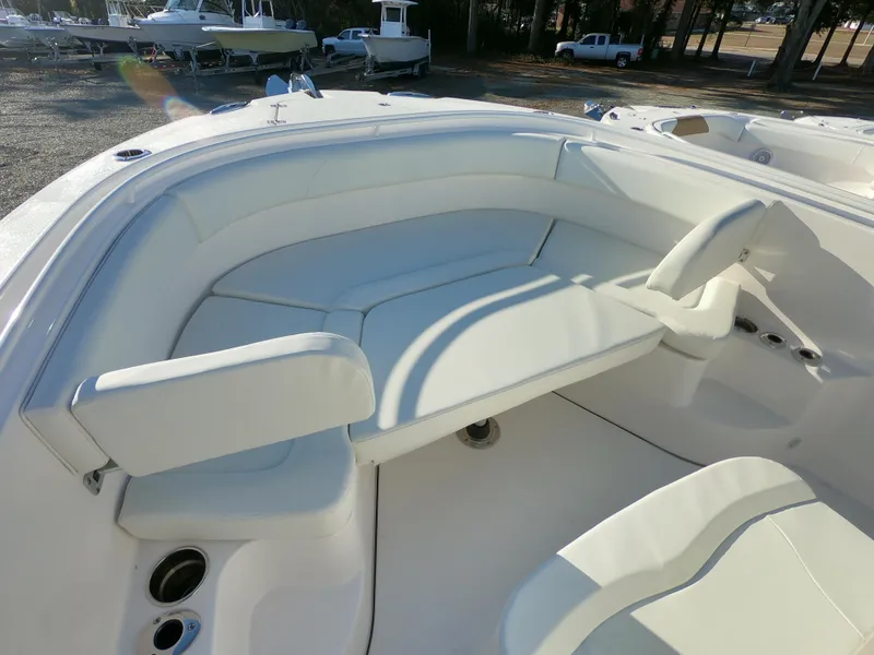 Slide: The Image of 2022 Edgewater 280CC boat interior with white seating and cup holders. - 27