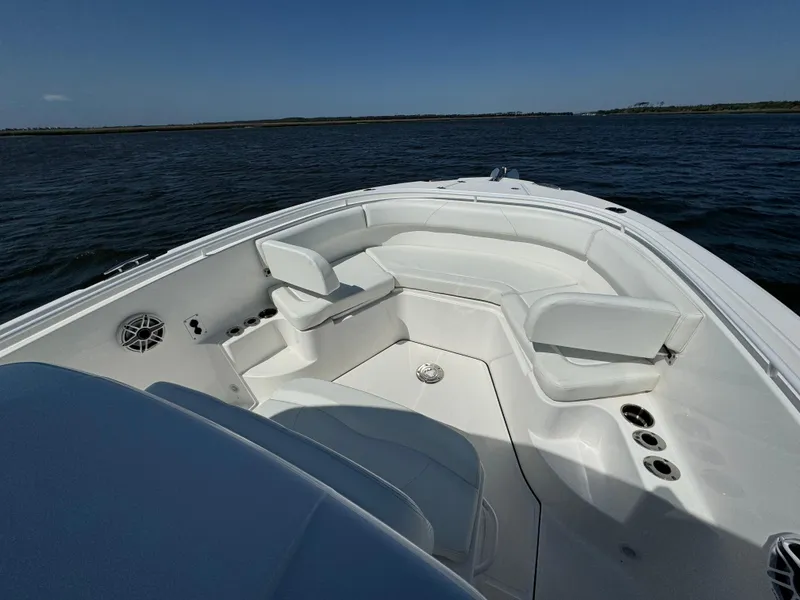 Slide: The Image of 2022 Edgewater 280CC boat interior with seating, cup holders, and ocean view. - 31