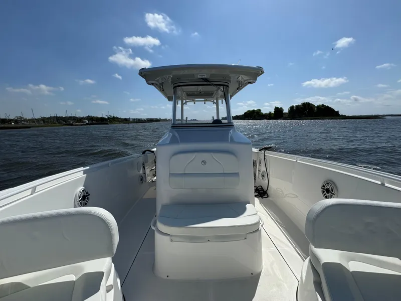 Slide: The Image of Edgewater 280CC 2022 boat on water, clear sky, spacious deck, comfortable seating. - 32