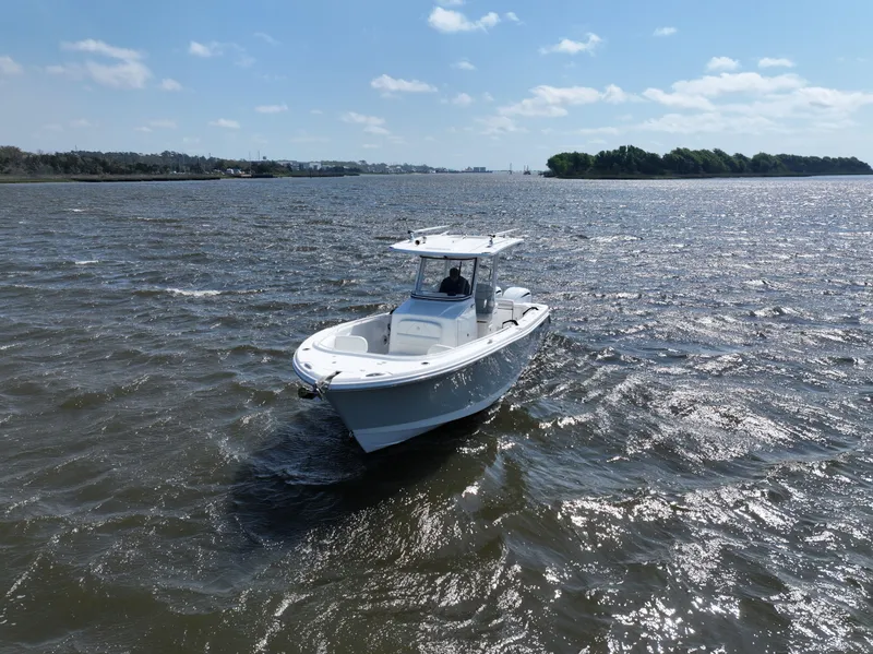 Slide: The Image of 2022 Edgewater 280CC boat cruising on a sunny day in open waters. - 4