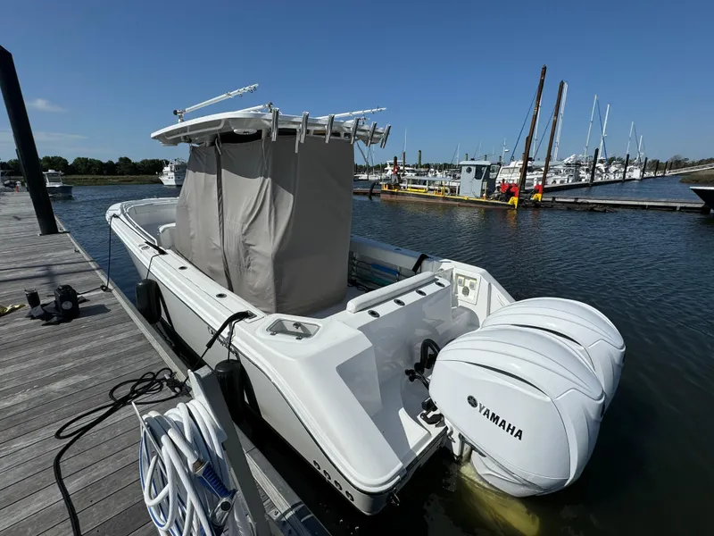 Slide: The Image of 2022 Edgewater 280CC boat docked with twin Yamaha engines, marina background. - 47