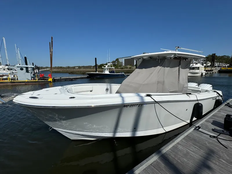 Slide: The Image of 2022 Edgewater 280CC boat docked at marina under clear blue sky. - 48