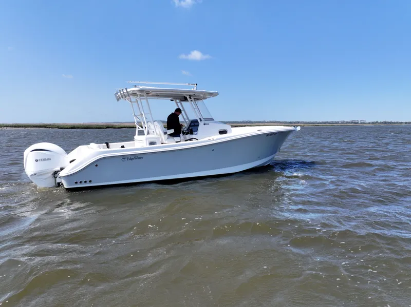 Slide: The Image of 2022 Edgewater 280CC boat cruising on open water under clear blue sky. - 5