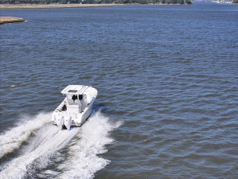 Slide: The Image of Edgewater 280CC 2022 boat cruising on open water, creating a wake. - 6